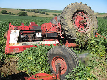 A color image of a tractor that has turned over.