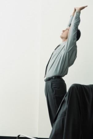 Man stretching next to office chair